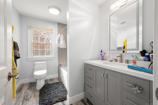 full bathroom with bathtub / shower combination, vanity, hardwood / wood-style floors, and toilet