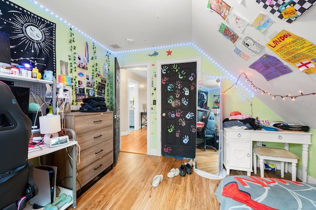 bedroom featuring lofted ceiling and light hardwood / wood-style flooring