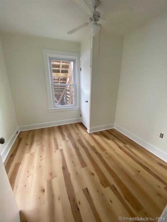 empty room with ceiling fan and light wood-type flooring