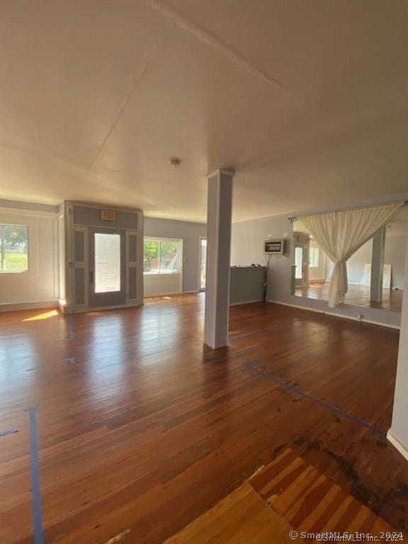 unfurnished living room with a wealth of natural light and dark hardwood / wood-style flooring