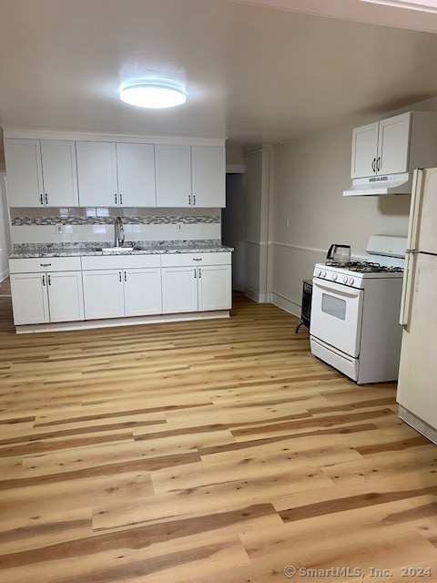 kitchen featuring white cabinetry, light stone countertops, light hardwood / wood-style flooring, sink, and white appliances