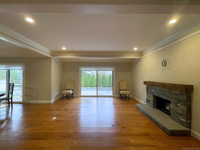 unfurnished living room featuring crown molding, a fireplace, and hardwood / wood-style floors