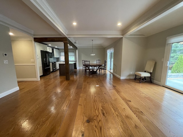 dining space with ornamental molding, hardwood / wood-style flooring, and baseboards