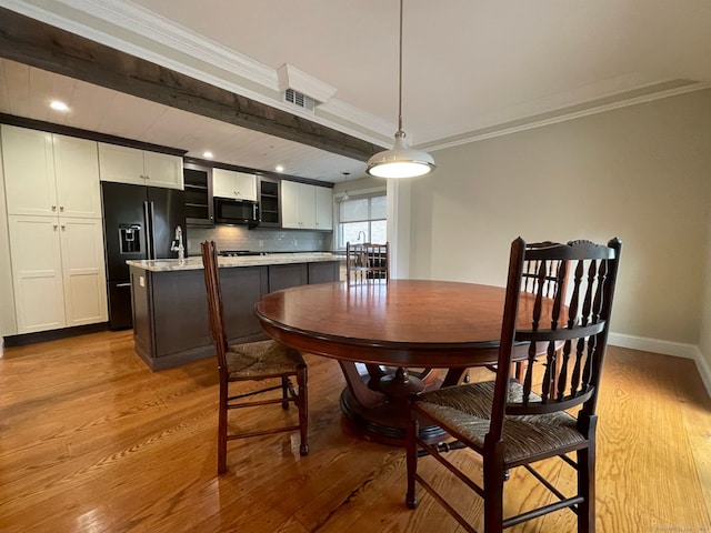 dining room featuring crown molding and light wood-type flooring