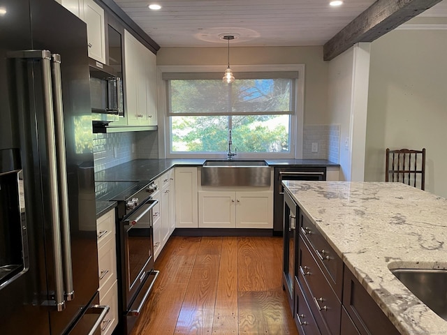 kitchen with dark wood finished floors, recessed lighting, stainless steel microwave, high end black refrigerator, and electric range