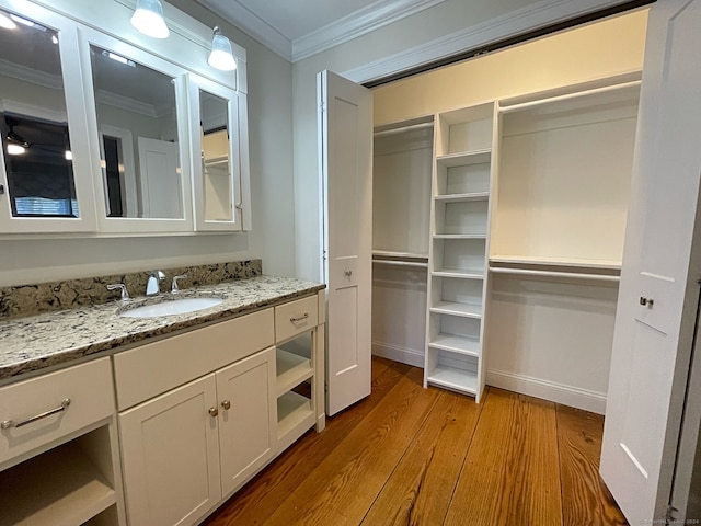 bathroom with vanity, wood-type flooring, and ornamental molding