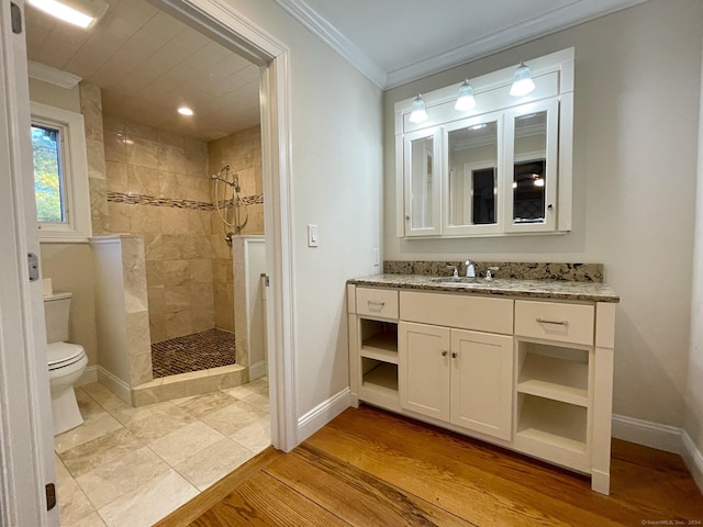 bathroom featuring a walk in shower, toilet, crown molding, and baseboards