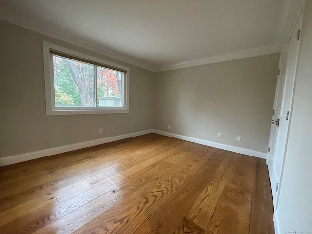 spare room featuring light hardwood / wood-style flooring and ornamental molding