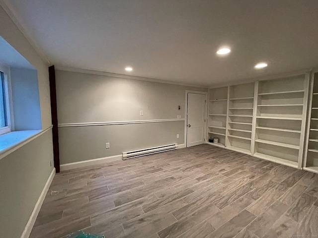 unfurnished room with baseboard heating, recessed lighting, wood finished floors, and baseboards