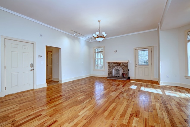 unfurnished living room featuring ornamental molding, light wood-type flooring, and plenty of natural light