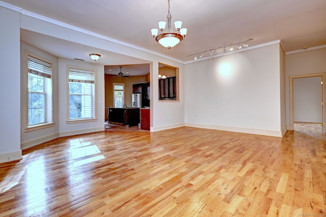 unfurnished living room with light hardwood / wood-style floors, ornamental molding, track lighting, and ceiling fan with notable chandelier