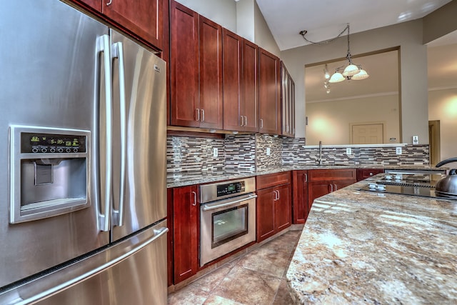 kitchen with appliances with stainless steel finishes, sink, light stone counters, a notable chandelier, and decorative backsplash