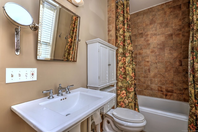 full bathroom featuring sink, toilet, and shower / bathtub combination with curtain