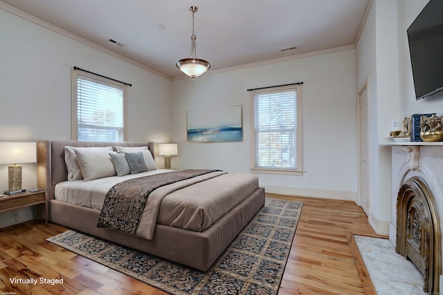 bedroom with crown molding, multiple windows, and light wood-type flooring