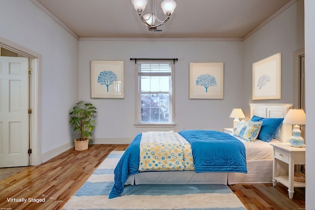 bedroom with ornamental molding, hardwood / wood-style flooring, and a chandelier