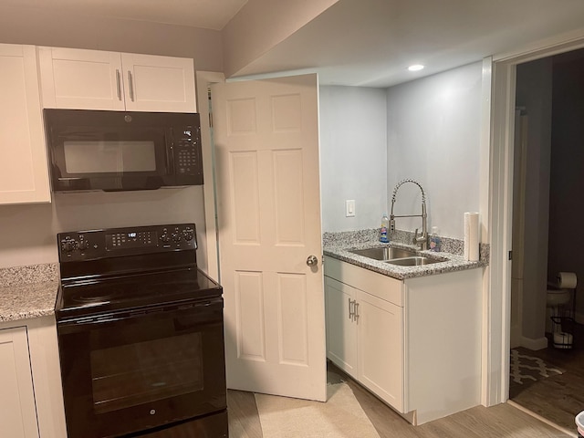 kitchen with sink, white cabinets, and black appliances