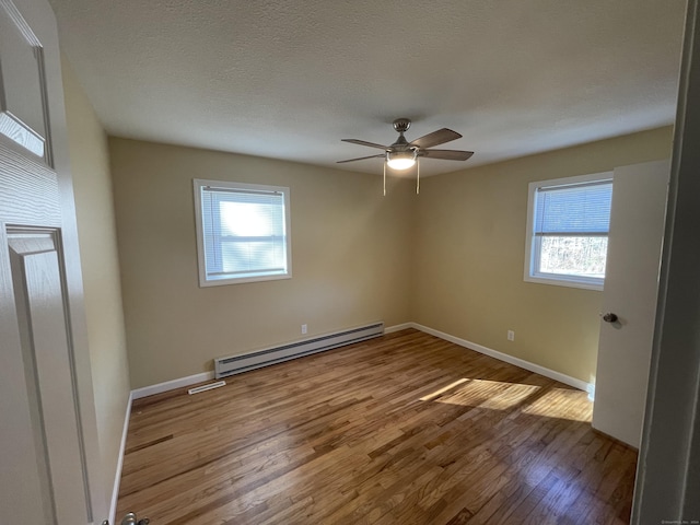 unfurnished room featuring hardwood / wood-style flooring, ceiling fan, a textured ceiling, and a baseboard radiator