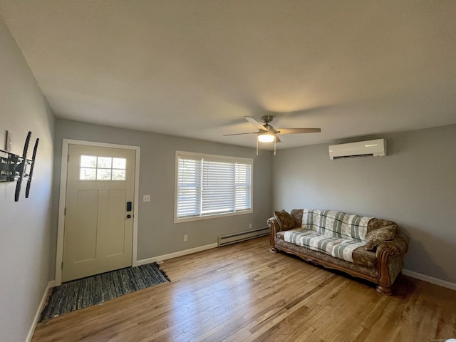 foyer featuring a baseboard radiator, an AC wall unit, ceiling fan, and light hardwood / wood-style floors