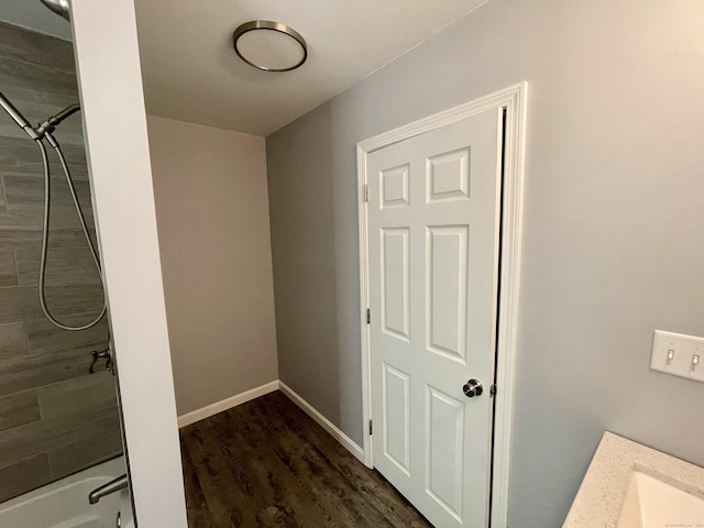 bathroom with hardwood / wood-style flooring and tiled shower / bath combo