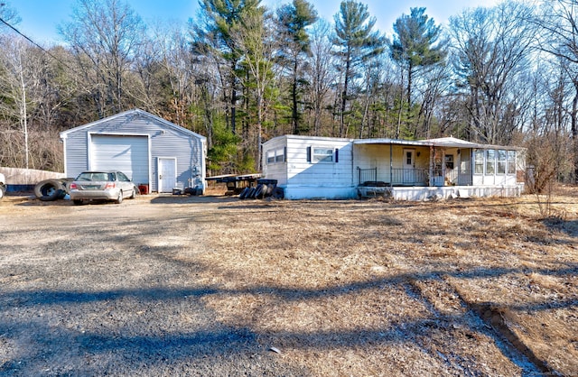 view of front of home with a garage, an outbuilding, and a porch