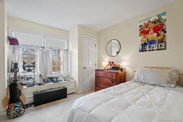 carpeted bedroom featuring a textured ceiling and a baseboard heating unit