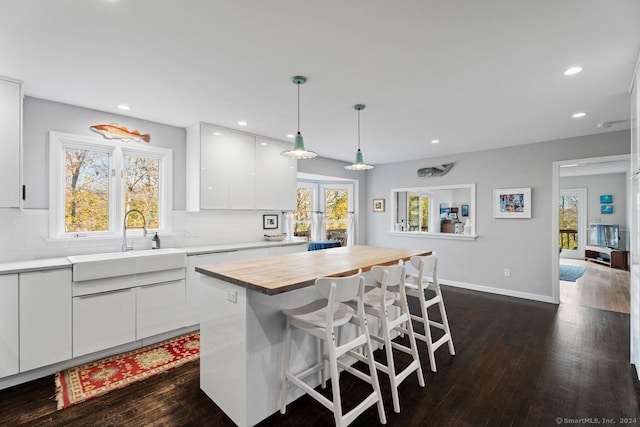 kitchen featuring white cabinets, a healthy amount of sunlight, and pendant lighting