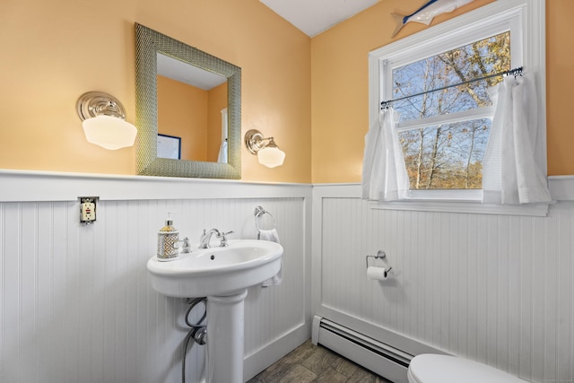 bathroom featuring a baseboard radiator, toilet, and hardwood / wood-style flooring