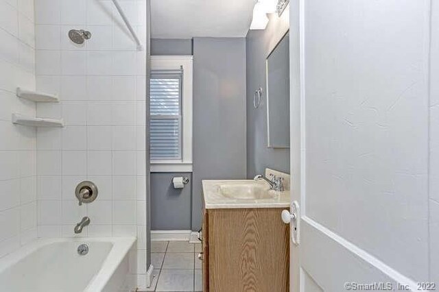 bathroom with vanity, tiled shower / bath combo, and tile patterned flooring