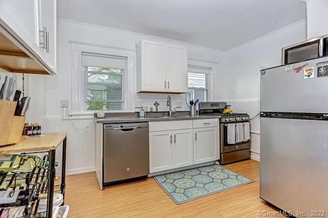 kitchen featuring appliances with stainless steel finishes, white cabinets, and plenty of natural light