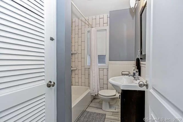 full bathroom featuring toilet, vanity, and shower / tub combo