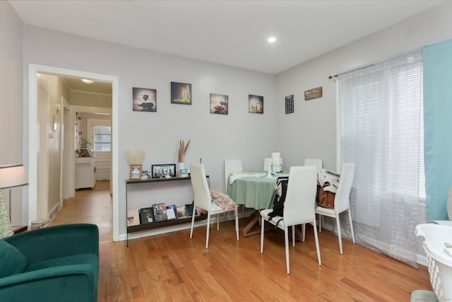 dining space featuring crown molding and light hardwood / wood-style flooring