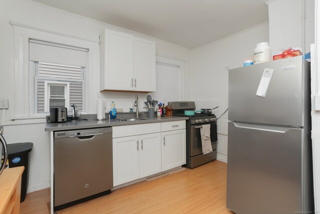 kitchen featuring white cabinets, light hardwood / wood-style flooring, sink, crown molding, and stainless steel appliances