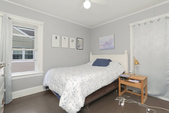 bedroom with dark hardwood / wood-style flooring, crown molding, and ceiling fan