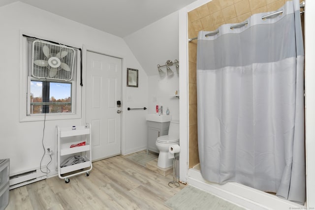 bathroom with toilet, hardwood / wood-style floors, a shower with curtain, and vaulted ceiling