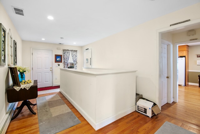 hallway featuring hardwood / wood-style flooring and baseboard heating