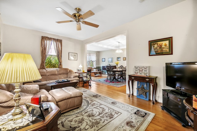 living room featuring hardwood / wood-style flooring and ceiling fan with notable chandelier