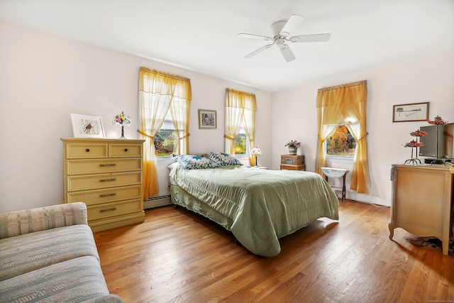 bedroom with a baseboard radiator, light hardwood / wood-style flooring, and ceiling fan