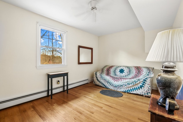 living area with ceiling fan, hardwood / wood-style flooring, and a baseboard radiator