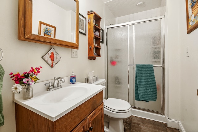 bathroom featuring vanity, an enclosed shower, hardwood / wood-style floors, and toilet