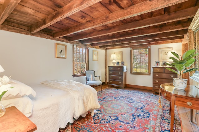 bedroom with beam ceiling, wood ceiling, multiple windows, and wood-type flooring