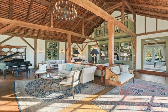 living room featuring hardwood / wood-style floors, high vaulted ceiling, an inviting chandelier, and beam ceiling