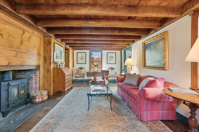 living room with beam ceiling, a wood stove, wooden ceiling, and dark hardwood / wood-style floors