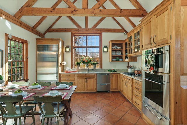 kitchen featuring appliances with stainless steel finishes, sink, high vaulted ceiling, and beam ceiling