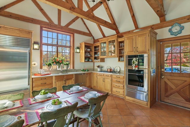 kitchen featuring beam ceiling, a wealth of natural light, sink, and stainless steel appliances