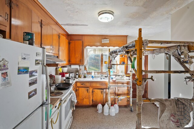 82 Pendleton Hill Rd, Voluntown, CT 06384 - kitchen with white appliances, under cabinet range hood, brown cabinets, and light countertops
