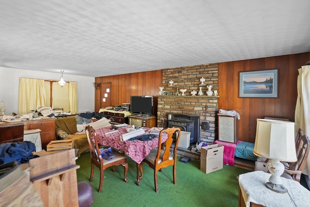 82 Pendleton Hill Rd, Voluntown, CT 06384 - carpeted dining room featuring wooden walls, a wood stove, and a textured ceiling
