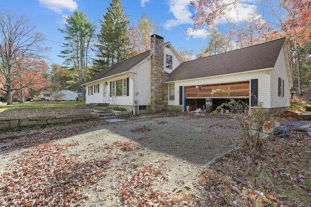 82 Pendleton Hill Rd, Voluntown, CT 06384 - back of house featuring a chimney, a garage, driveway, and a shingled roof