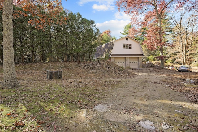 82 Pendleton Hill Rd, Voluntown, CT 06384 - view of property exterior with a gambrel roof, dirt driveway, and an attached garage