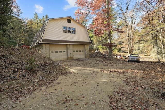 82 Pendleton Hill Rd, Voluntown, CT 06384 - view of side of property with a gambrel roof, driveway, a garage, and an outbuilding