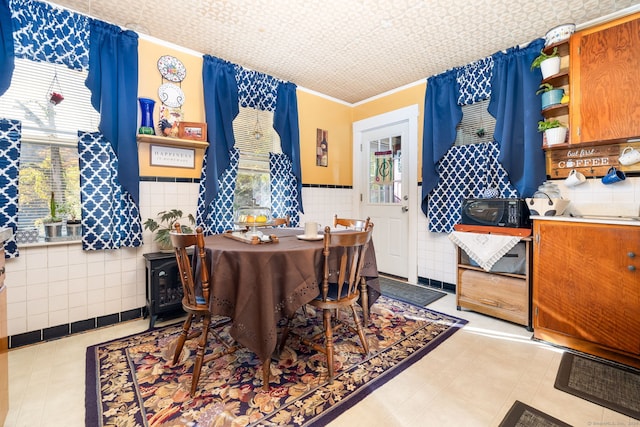 dining space featuring tile walls, wainscoting, and tile patterned floors